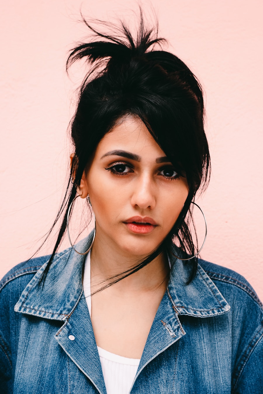 Monochrome portrait of a model in a denim jacket against a plain wall